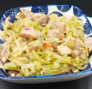 Asian Cabbage Stir Fry is in blue rectangle bowl on black mat.