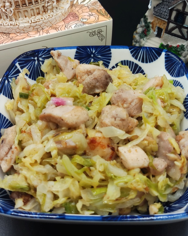 Asian Cabbage Stir Fry is in blue rectangle bowl on black mat.