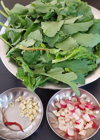 Two bowls of chopped vegetables: radishes, garlic, and leafy greens