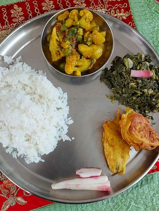 Homemade mooli ka saag with white rice, Pakoda, cauliflower curry and few sliced of mooli.