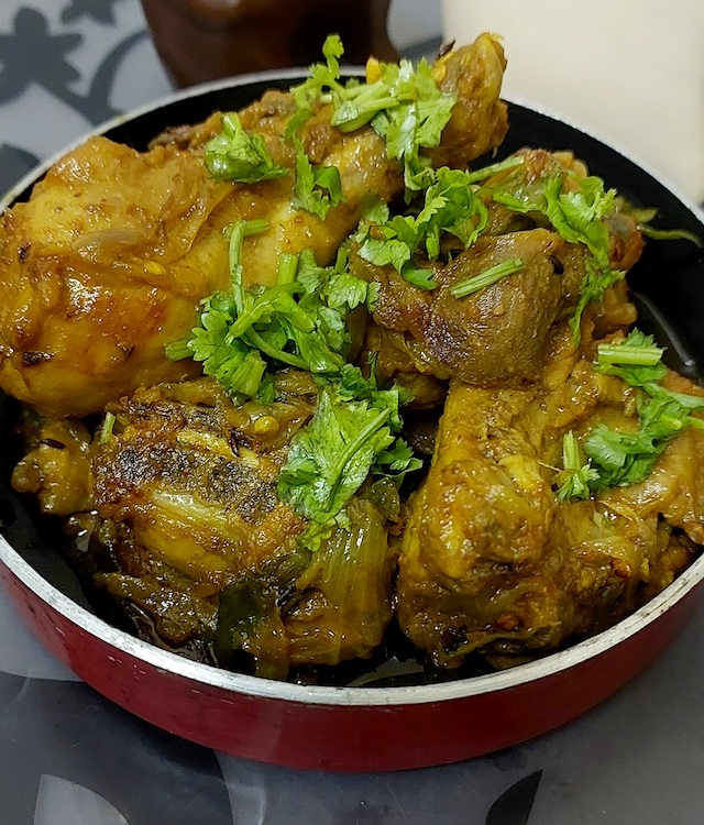 "Jhatpat Chicken Recipe - Spicy chicken in a pan with aromatic spices and fresh coriander leaves."