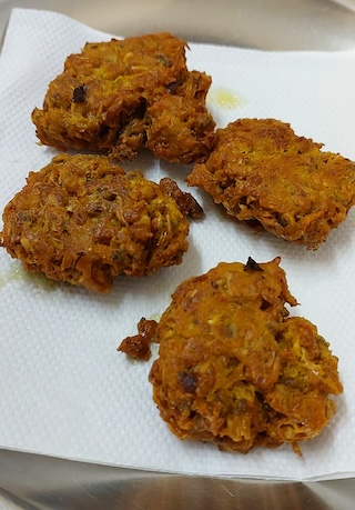 Moringa Flower Fritters on white tissue paper.