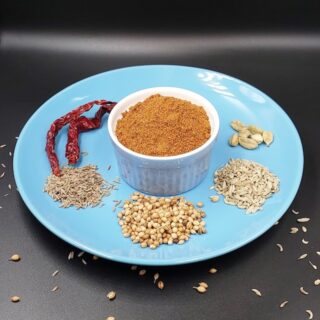 A small bowl of Bengali Bhaja Masala, a traditional spice blend featuring roasted and ground spices, ideal for enhancing the flavors of various Bengali dishes.