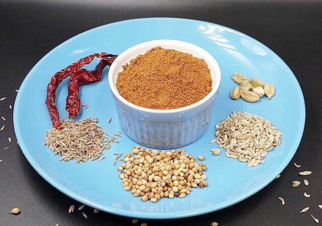 A small bowl of Bengali Bhaja Masala, a traditional spice blend featuring roasted and ground spices, ideal for enhancing the flavors of various Bengali dishes.