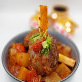 Slow-Cooked Lamb Shank with Vegetables: "Tender slow-cooked lamb shank served with potatoes, carrots and onions.