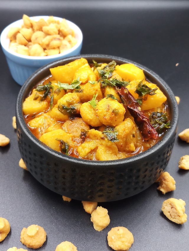 A bowl of Aloo Badi Ki Sabji garnished with fresh coriander leaves.