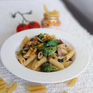 A bowl of Rigatoni Aglio e Olio garnished with basil.