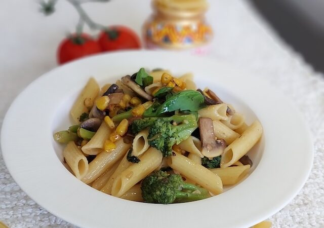 A bowl of Rigatoni Aglio e Olio garnished with basil.