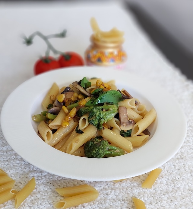 A bowl of Rigatoni Aglio e Olio garnished with basil.